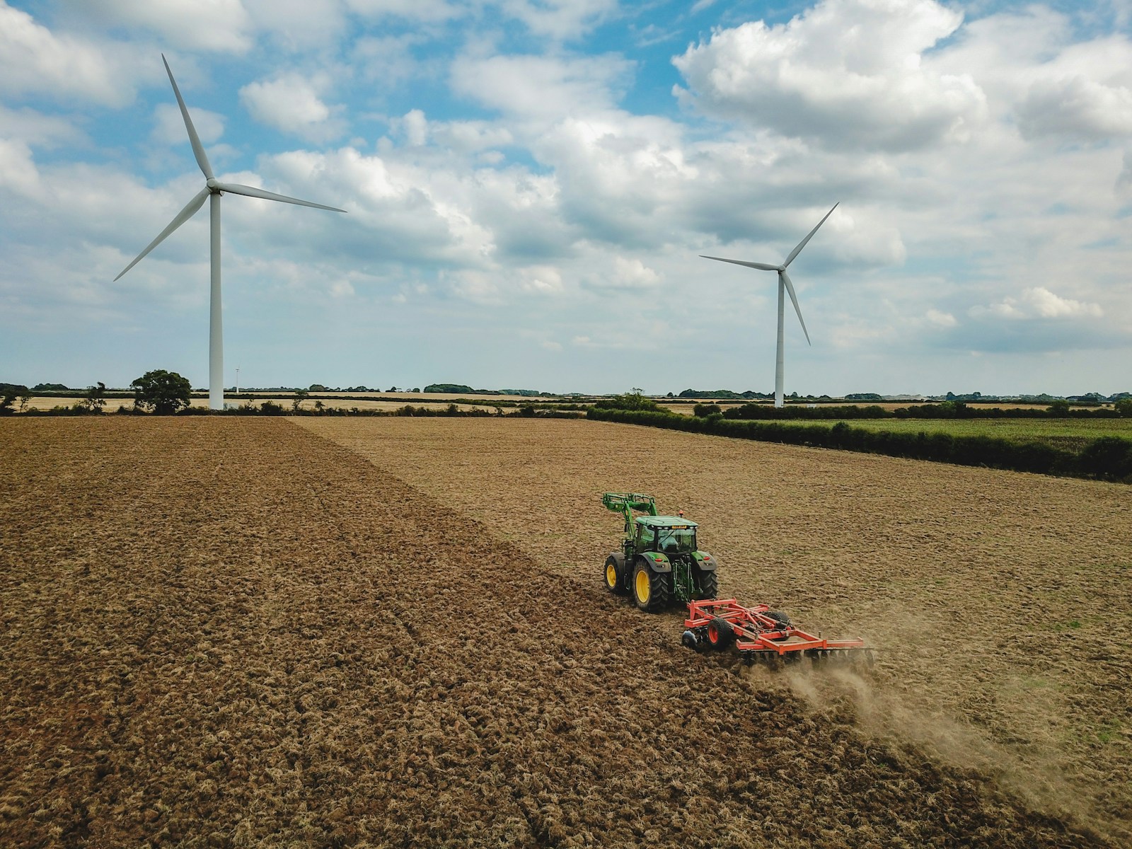 UK farming health and safety green and red tractor on brown field under blue and white cloudy sky during daytime